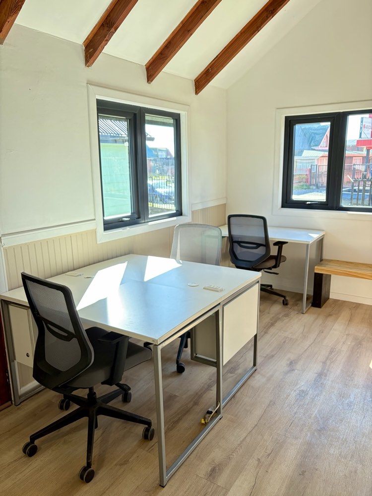 Interior del cowork Espacio Montt, escritorios compartidos y techo con vigas a la vista