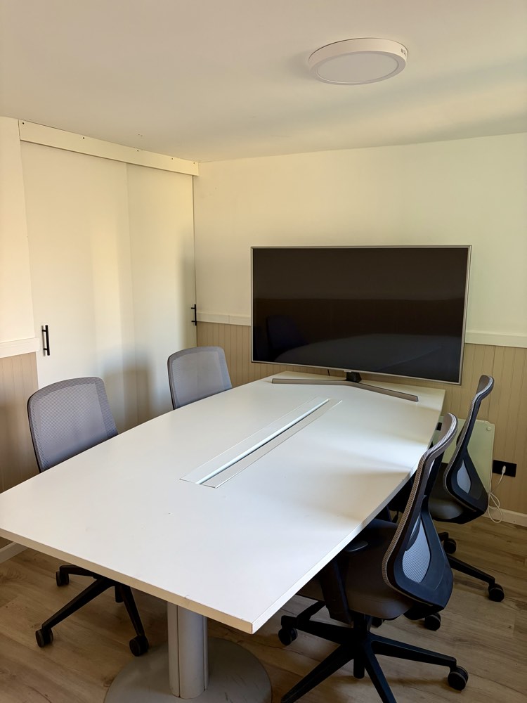 Sala de reuniones de Espacio Montt, mesa para seis personas con pantalla